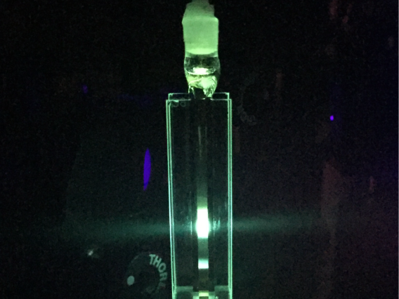 Bright fluorescent light coming from a liquid in a glass cuvette