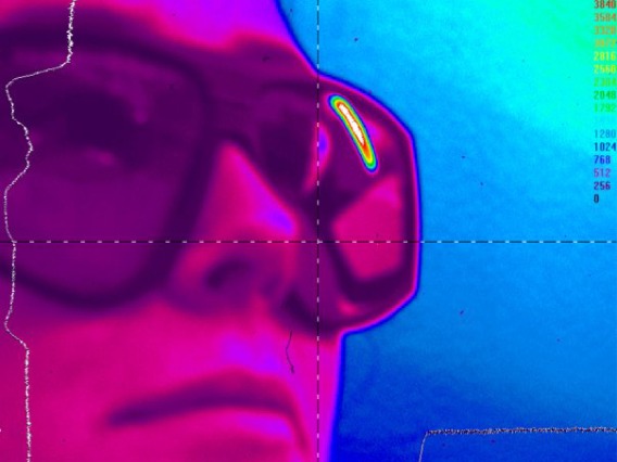 Blue and bright pink image of person wearing laser goggles