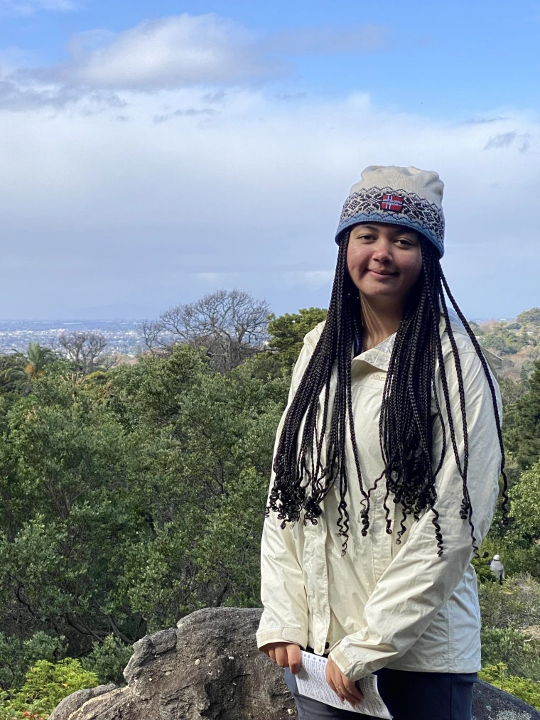 Picture of woman standing on a mountain with a beautiful background